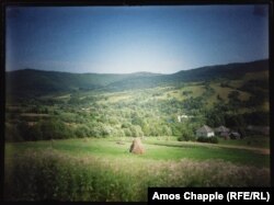 Baloturi de fân și terenuri agricole în jurul unui sat din Carpații ucraineni.