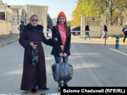 თბილისის საქალაქო სასამართლოსთან ბაია დედასთან ერთად ელოდება, როდის დააკავებენ პოლიციელები - ჩანთა საჭირო ნივთებით თან აქვს.