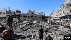Palestinians inspect the damage after an Israeli strike in the Al-Bureij camp in the central Gaza Strip on July 4, 2025.