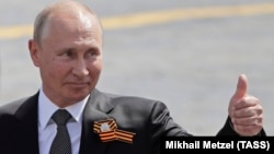 Russian President Vladimir Putin gestures to onlookers following a rescheduled Victory Day parade on Moscow's Red Square on June 24. 