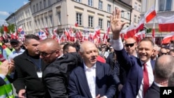 Candidatul conservator la președinția Poloniei Karol Nawrocki (dreapta) la un marș electoral pe 25 mai 2025, în Varșovia