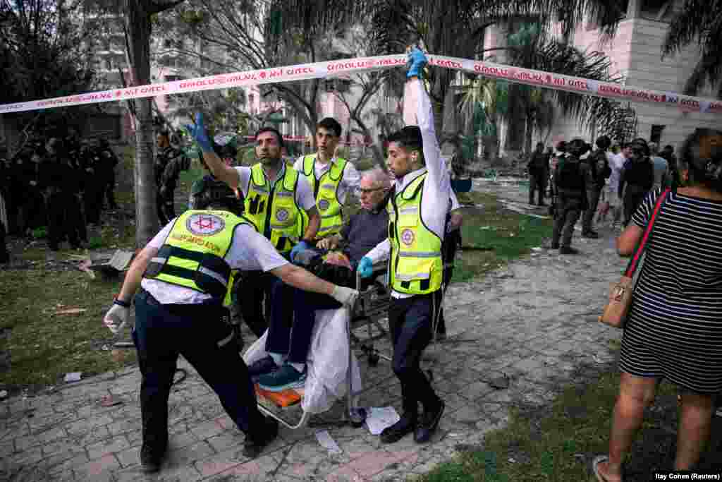 Spasilačke ekipe evakuišu muškarca iz zgrade pogođene iranskom raketom, u centralnom Izraelu, 16. juna.