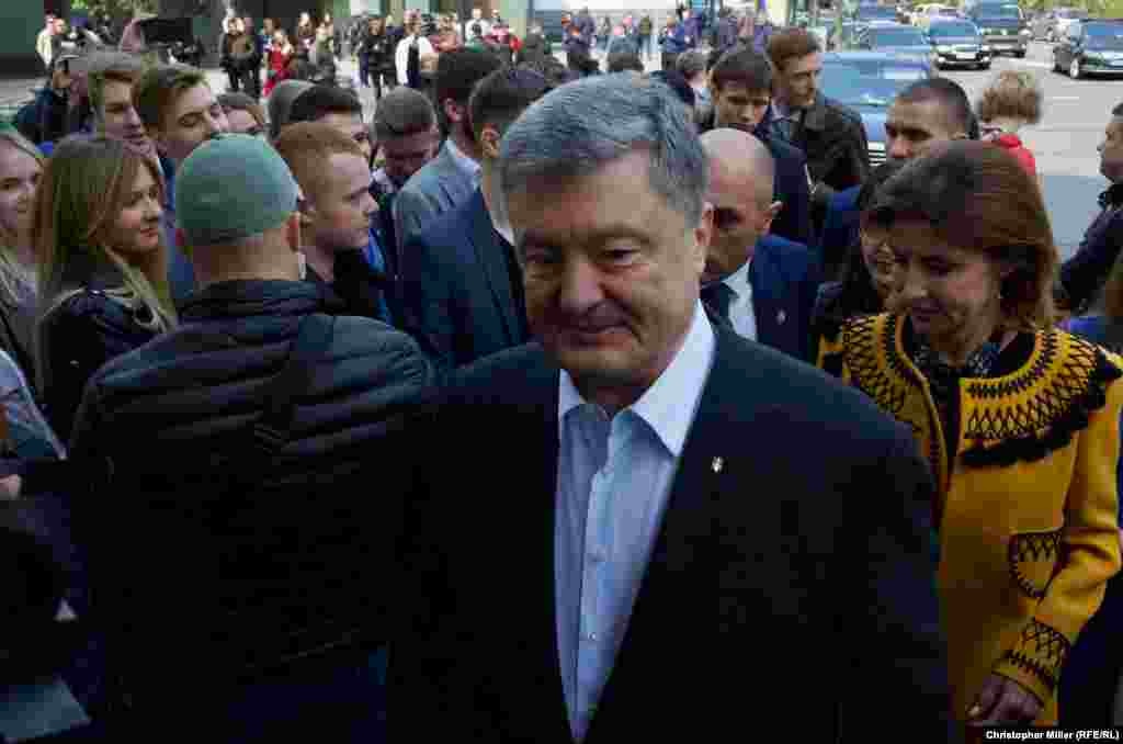 Incumbent President Petro Poroshenko speaks to RFE/RL as he arrives at Kyiv's House of Officers to cast his ballot with his wife, Maryna Poroshenko, on April 21.