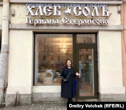 Вера Врубель перед магазином "Хлеб Соль". В витрине – временная табличка