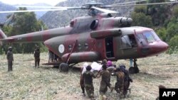 Soldați talibani duc o victimă spre elicopter în satul Mazar Dara, pe 2 septembrie.