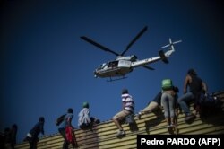 Группа нелегалов перебирается через пограничную стену в США. Тихуана, Мексика, 25 ноября 2018 года
