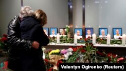 Relatives of flight crew members of the Ukraine International Airlines Boeing 737-800 plane that crashed in Iran mourn at a memorial in Boryspil airport outside Kyiv on January 8. 