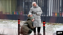 Каза болгон окуучу Кобилжон Алиевдин туугандары мектептин алдында турушат 