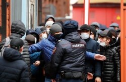 Трудовые мигранты в очереди на продление разрешения на проживание в России возле миграционного центра в Санкт-Петербурге. Апрель 2020 года. Фото: EPA.