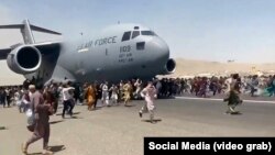 Кабулдагы аэропортто АКШнын аскердик учагынын жолун тосууга аракет кылган ооган жарандар.  16-август, 2021-жыл.