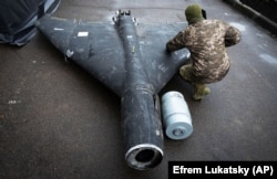 Український військовий оглядає збитий безпілотник Shahed із термобаричним зарядом, листопад 2024 року