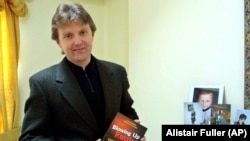 Aleksandr Litvinenko pozează cu cartea sa, Blowing Up Russia: Terror From Within, la casa sa din Londra în mai 2002.