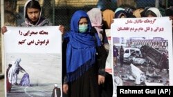 FILE: Afghan women activists hold banners highlighting alleged Taliban atrocities. 