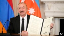 U.S. - Azerbaijan President Ilham Aliyev holds a signed trilateral agreement during a ceremony with Armenian Prime Minister Nikol Pashinian and President Donald Trump at the White House, August 8, 2025.