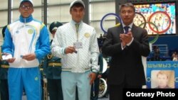 Казахстанские спортсмены (слева) и руководитель Агентства спорта ии физической культуры Казахстана Талгат Ермегияев во время вручения удостоверений для участников предстоящей Олимпиады в Лондоне. Астана, июль 2012 года.  