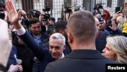 Candidatul prorus Călin Georgescu și-a depus vineri candidatura pentru alegerile prezidențiale din luna mai. Aici, în fața Biroului Electoral Central, cu soția sa, Cristela. El și-a făcut loc printre susținători cu ajutorul bodyguarzilor.