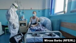 Asistent-șef Ionela Mitrache (stânga) în timpul vizitei la pacienții Covid-19 din spitalul „Caritas”