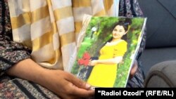 Мать держит в руках фото умершей дочери Розии