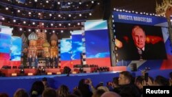 Președintele rus Vladimir Putin vorbește pe o scenă instalată în Piața Roșie din centrul Moscovei, 30 septembrie 2022, în timpul unui concert care marchează anexarea ilegală a teritoriilor controlate de Rusia din patru regiuni ucrainene.