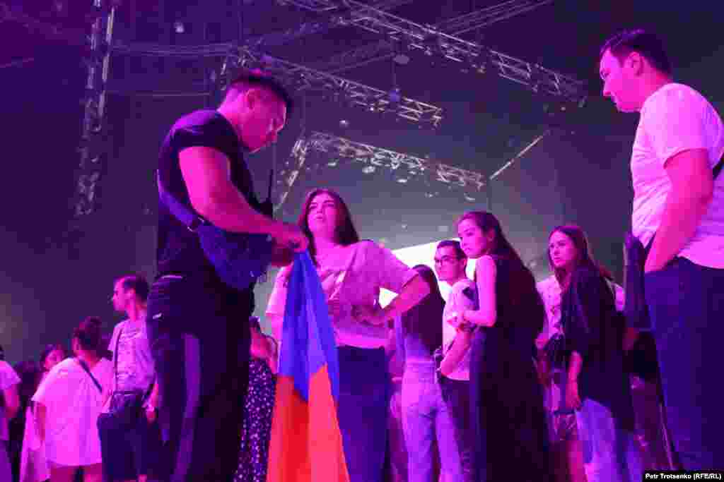 &ndash; Туды әкеткен күзетшілер концерттен соң қайтарамыз деді. "Саяси атрибуттарды не үшін алып жатырсыздар?" деп сұрағыма "ұйымдастырушылардың талабы" деп жауап берді, - дейді Лиза (ортада) есімді көрермен.&nbsp;