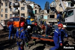 Спасители носят тялото на човек, открит сред отломките от среднощната атака на Русия срещу украинската столица Киев, 28 август 2025 г.