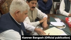 د خيبرپښتونخوا وزيراعلا محمود خان د جانيخېلو له مشرانو سره پر تړون لاسليک کوي. د ارشیف انځور