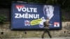 Un pieton trece pe lângă un panou electoral al unui partid de extremă dreapta care îndeamnă cehii să „voteze pentru schimbare”. 