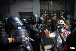 Protestatarii reacționează în fața poliției franceze în timp ce mărșăluiesc la Lyon
