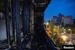 Vedere asupra Kievului de pe balconul unui bloc lovit de atacul rusesc.