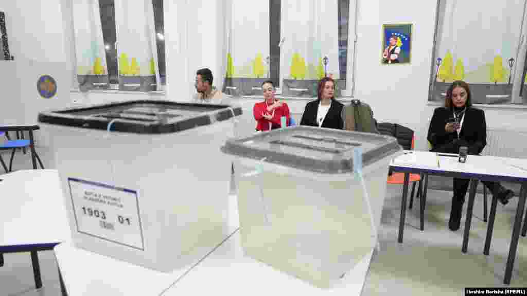 Zyrtare të Komisionit Qendror të Zgjedhjeve shikojnë teksa presin në një qendër votimi në Prishtinë ardhjen e votuesve për ta hedhur votën e tyre në zgjedhjet lokale të Kosovës, 12 tetor 2025.