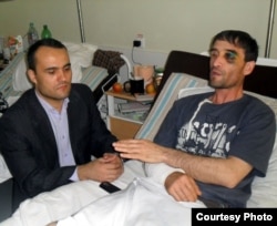 Izzat Amon Moskwanyň keselhanalarynyň birinde, urlup-ýenjilen täjik migranty bilen. Arhiw suraty.