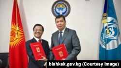 Бишкек шаарынын мэри Айбек Жунушалиев менен "РЦА Ливингдин" директору Фан Ань Шон инвестициялык келишимге кол коюшууда.