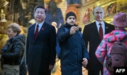 Картонные фигуры председателя КНР Си Цзиньпина и российского президента Владимира Путина на улице Арбат в Москве. 15 ноября 2023 года