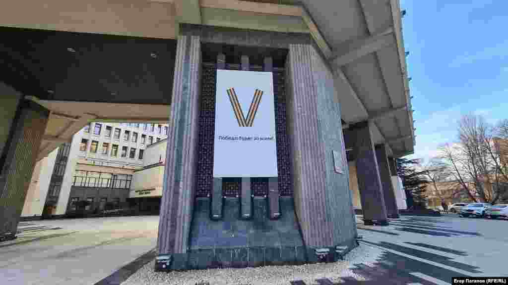 Буква V (один из символов полномасштабной войны России против Украины) с подписью «Победа будет за нами» на фасаде здания подконтрольного Москве крымского парламента