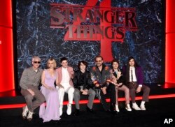 Matthew Modine, stânga, Cara Buono, Noah Schnapp, Finn Wolfhard, David Harbour, Gaten Matarazzo și Eduardo Franco pozează împreună la premiera sezonului patru din „Stranger Things” în New York.