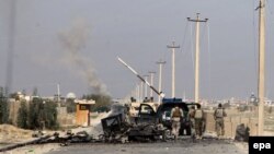 Afghan security forces walk past the wreck of a burnt out vehicle en route to the center of Kunduz (file photo)
