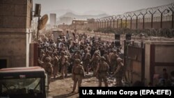 Trupat amerikane duke u ofruar ndihmë afganëve në Aeroportin e Kabulit që të largohen nga shteti. 21 gusht 2021. 