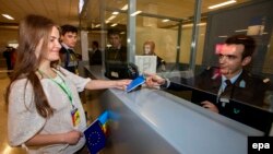 O moldoveancă își prezintă pașaportul la controlul vamal pe Aeroportul Internațional Eleftherios Venizelos din Atena, în cadrul primului zbor fără viză spre o țară UE, 28 aprilie 2014.