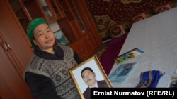 Чынара Бечелова маркум күйөөсүнүн сүрөтүн кармап турат. 2011-жылы тартылган сүрөт.