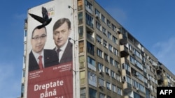 Un banner cu liderii Uniunii Social-Liberale (USL), premierul român Victor Ponta (L) și liderul Partidului Național Liberal Crin Antonescu (R) este postat pe un bloc din București, România, pe 8 decembrie 2012. Alegeri parlamentare, 9 decembrie 2012.