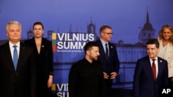 Schimb de priviri între vecini: Zelenski și Dan (în rândul de jos) la summitul de la Vilnius.