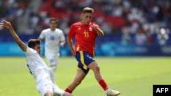 Abduqodir Husanov 2024-yilgi Parij olimpiadasida O‘zbekiston jamoasining Ispaniyaga qarshi o‘yinida dunyoning eng tez o‘yinchilaridan bo‘lgan Fermin Lopesdan to‘pni olib qo‘yyapti.