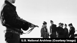 გერმანელი სამხედრო ტყვეების ჯგუფი სანაპირო დაცვის საბრძოლო კატარღის გემბანზე გრენლანდიის ჩრდილო-აღმოსავლეთ სანაპიროზე, მეორე მსოფლიო ომის დროს. ფოტო: U.S. National Archives (Courtesy Image)