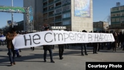 Люди на митинге в знак солидарности с бастующими Жанаозена держат баннер с надписью "Не стреляйте в народ".  Актау, 18 декабря 2011 года. Фото предоставлено фотокорреспондентом газеты "Лада" Ольгой Ярославской. 