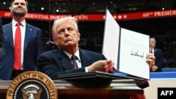 АКШ президенти Дональд Трамп жарлыктарга кол коюп жатат.  Capital One Arena. 20-январь, 2025-жыл.