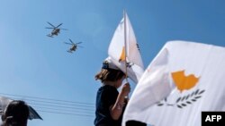 Тестиер бала Кипрдин желегин булгалоодо.  Никосия шаары. 2019-жылдын 1-октябры.