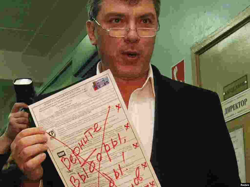 Opposition figure Boris Nemtsov shows his ballot, which reads "Give back the elections, Vermin! Boris Nemtsov," at a polling station in Moscow.