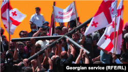 რადიკალური ჯგუფების წევრებს პარლამენტის წინ რკინის ჯვარი მიაქვთ. 5 ივლისი, 2021 წელი