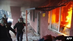 Pro-Russia protesters wearing gas masks storm a regional police building as one prepares a Molotov cocktail in Horlivka.