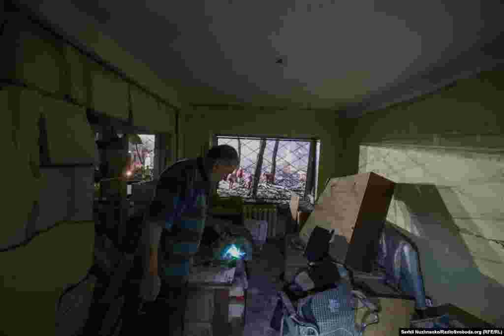 Një banor vlerëson dëmet në banesën e tij në Kiev.